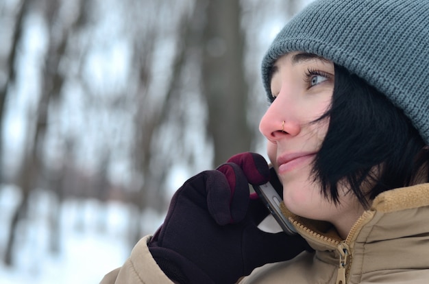 Winter portrait of young girl with smartphone