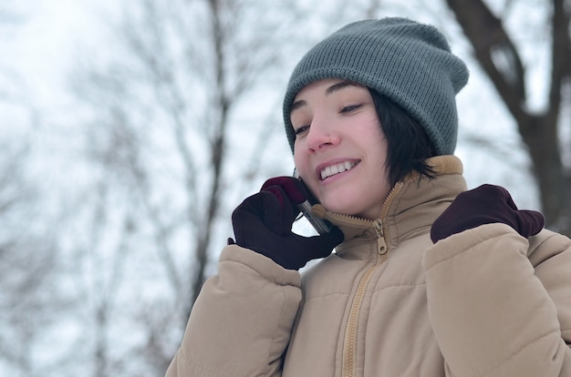 Winter portrait of young girl with smartphone