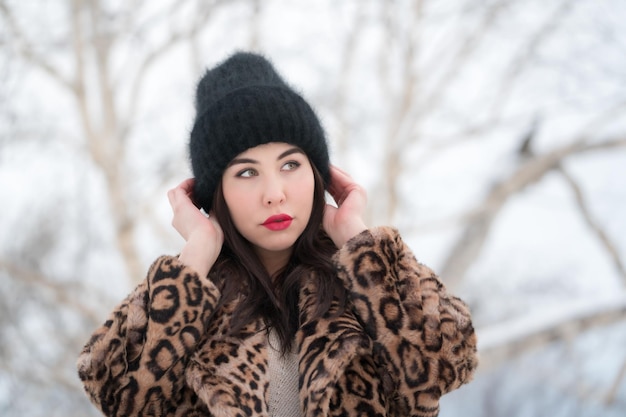 Winter portrait of young woman with long hair and red plump lips thoughtful looking away