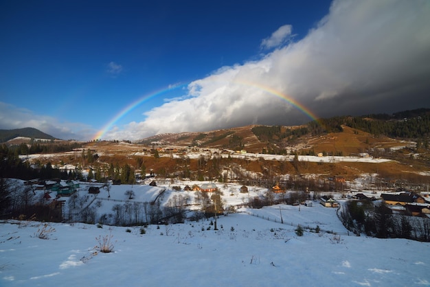 Winter rainbow. Mountain village. Beauty in nature. Carpathians, Ukraine, Europe