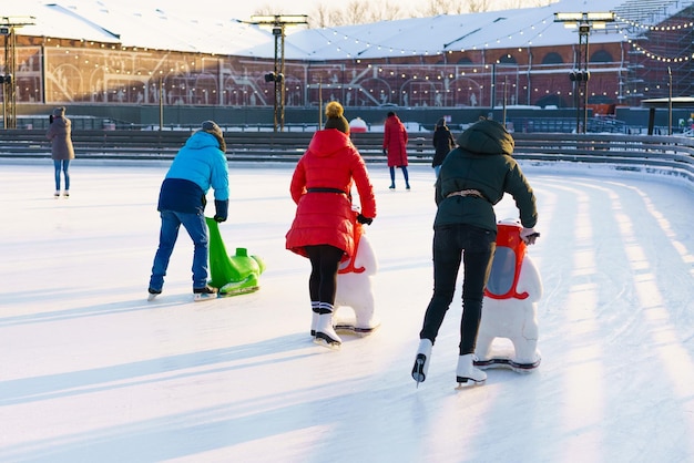 Winter rink Girls on skates ride on ice Active family sport during kids