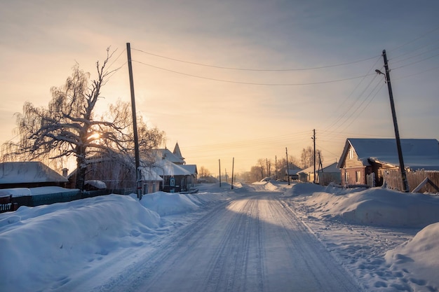 Winter road through a snowcovered village severe frost snow haze