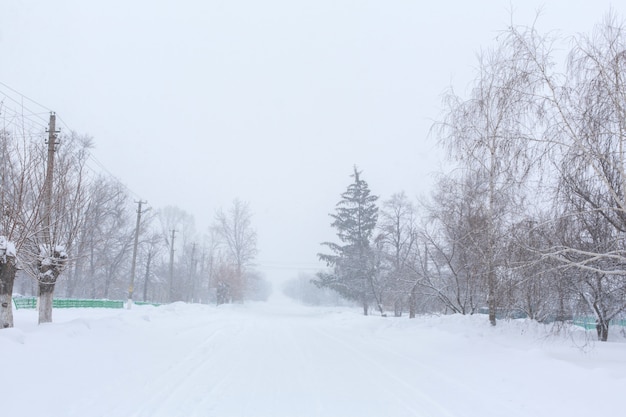 Winter, rural streets are covered with snow. Snow blizzard