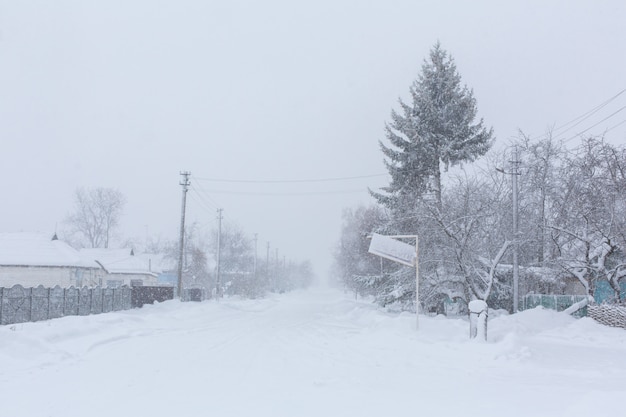 Winter, rural streets are covered with snow. Snow blizzard.