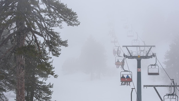 Winter sports in bad weather ski lift in the fog Mount Olympus ski resort Cyprus