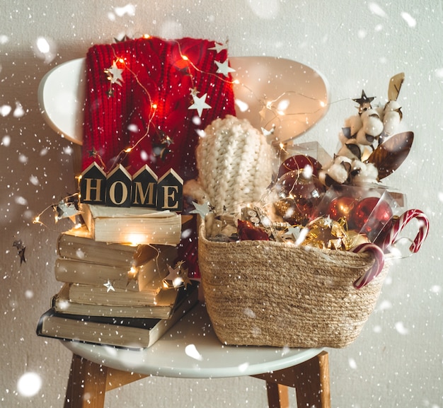 Winter sweater laid on a chair with a basket of Christmas decorations