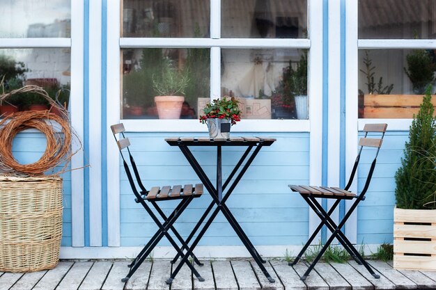 Winter terrace with wicker baskets and green plants in pots on porch home.