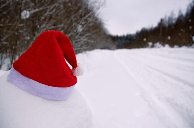 Winter trip. New Year's background. Santa Claus hat in the snow.