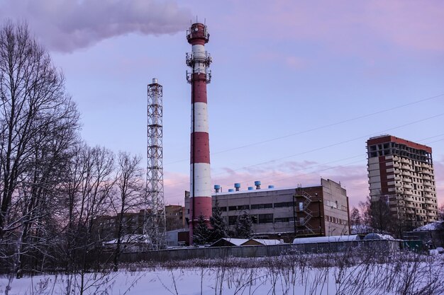 Winter view of a heating station with a smoking chimney