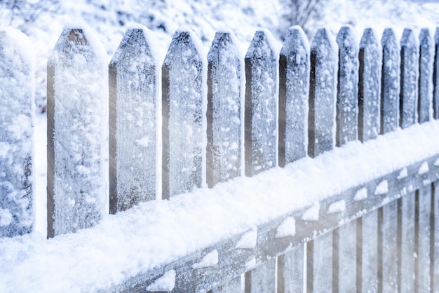 Winter in the village Wooden fence covered with a lot of snow Sun rays