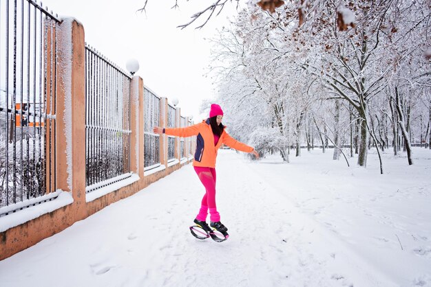 Winter workout exercising in cold weather winter fitness trening kangoo jumps sporty woman in