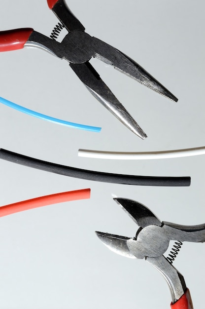 Wire cutters and heat shrink tubes. light background close-up.