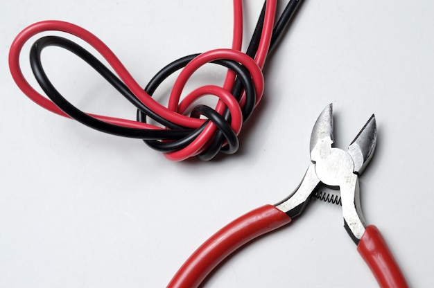 wire stripper, shielded three-core wire and wire cutters on a white background. close-up