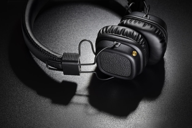 Wireless black onear headphones on dark slate background