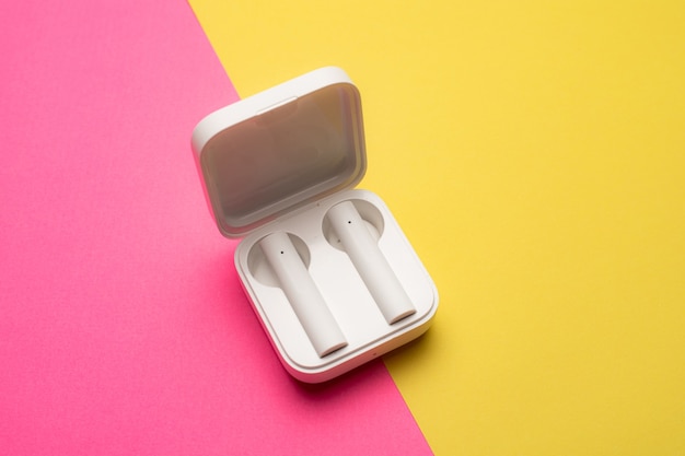 Wireless headphones on a pink background . Bright background. White headphones.