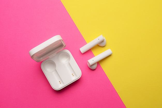 Wireless headphones on a pink background . Bright background. White headphones.