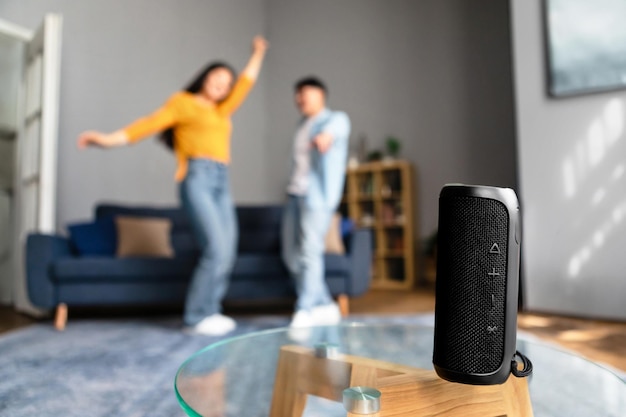 Wireless smart speaker playing song for dancing couple at home