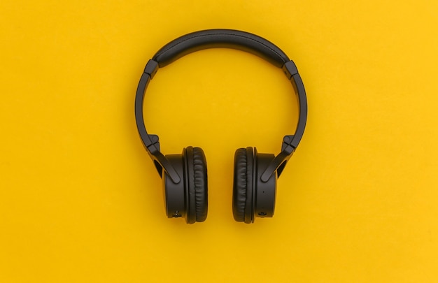 Wireless stereo headphones on yellow background. Top view