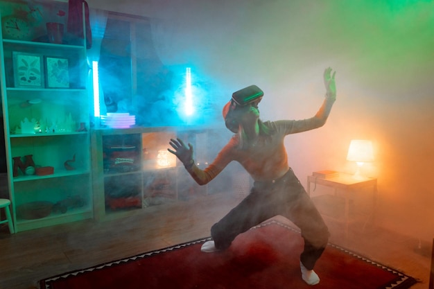 Wireless technologies Young woman using virtual reality glasses in the dark room with neon lighting