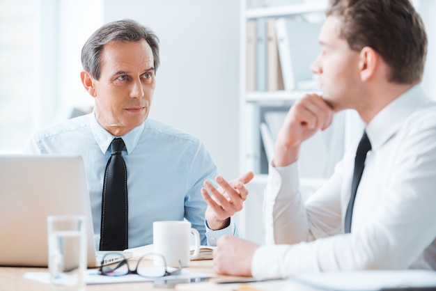 Wise advice for business nice. Two business people in formalwear discussing something 