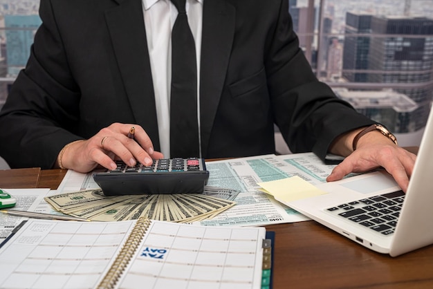 Wise male businessman working with important documents at office desk