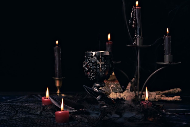 Witchcraft composition with burning candles books jewelry and pentagram symbol occult concept black magic ritual