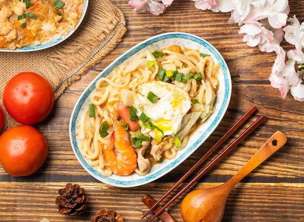 With tomato and chopsticks served in dish on wooden table top view of chines food