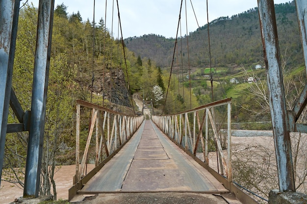 Wobbly old bridge over a mountain river for cars