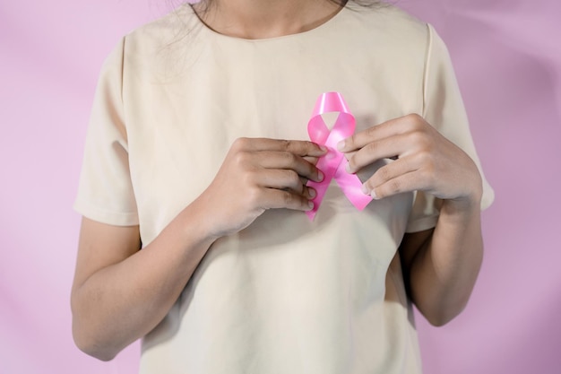 Womaen hand holding pink ribbon breast cancer awareness concept healthcare and medicine cancer concept