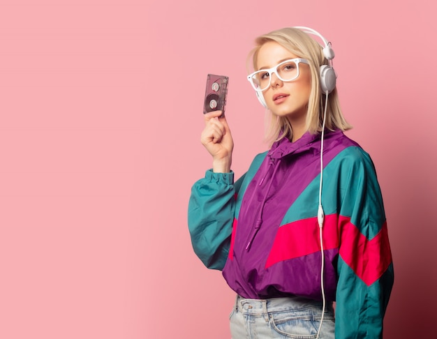 Woman in 90s clothes with headphones and audio cassette