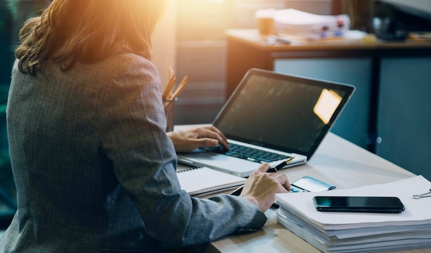 Woman accountant use calculator and computer with holding pen on