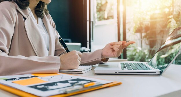 Woman accountant use calculator and computer with holding pen on