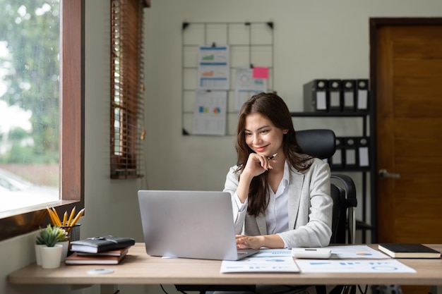 Woman accountant using calculator and computer in office finance and accounting concept