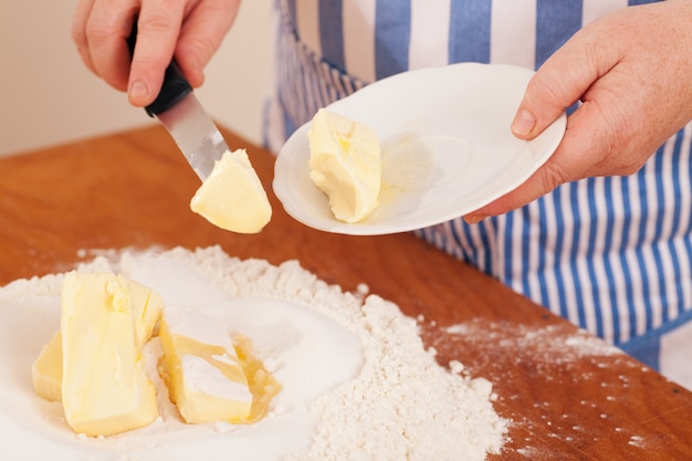 Woman adding butter to a mix