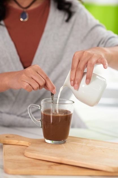 Woman Adding Milk in Coffee