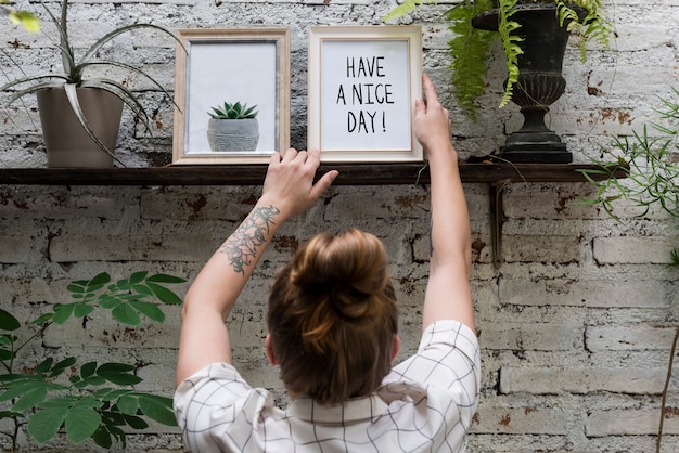 Woman adjusting Have a nice day photo frame on shelf