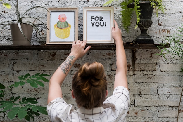 Woman adjusting For you photo frame on shelf