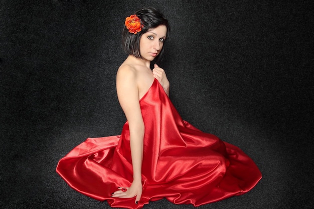 Woman against the dark background in the red cloth