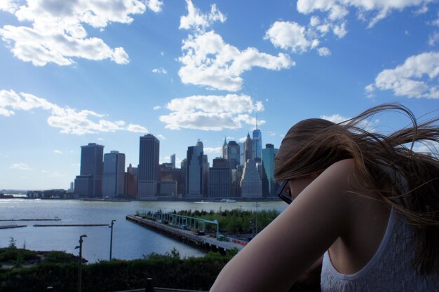 Photo woman against river and buildings in city