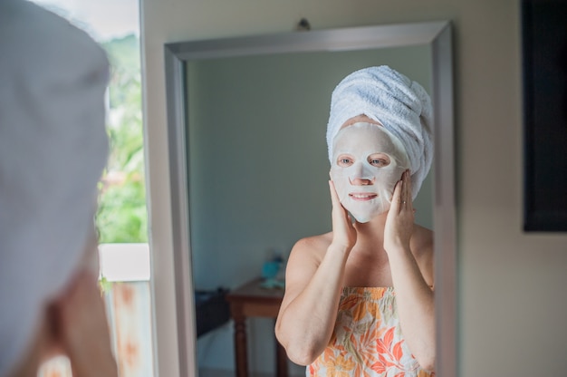 woman applying a facial mask sheet