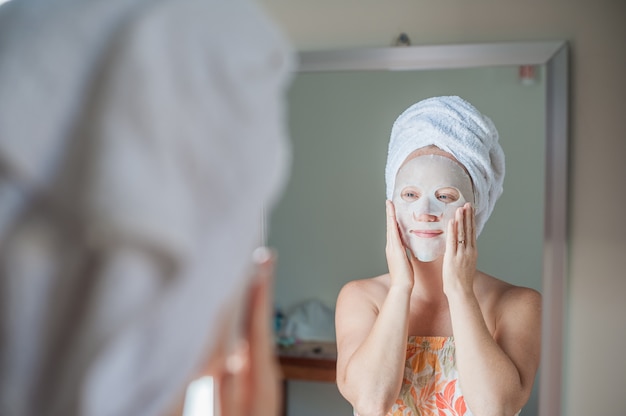 woman applying a facial mask sheet