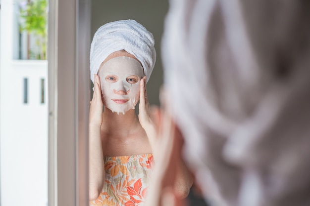 woman applying a facial mask sheet