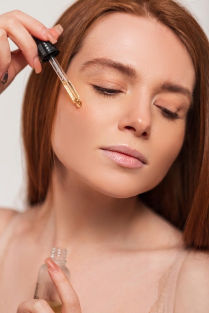 A woman applying liquid on her face