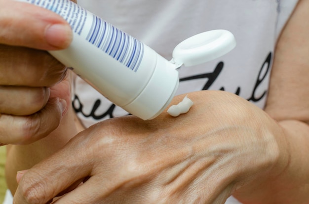 Photo woman applying moisturizer on her hands