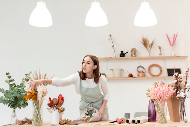 Woman arranging bouquets of flowers in her shop