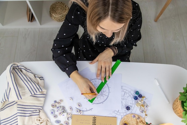 Woman astrologer draws a natal chart Selective focus