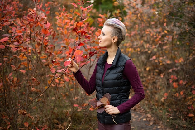 Woman in autumn forest background with golden and red trees