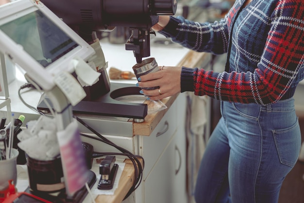 Woman barista filling jar with ground coffee