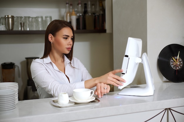 A woman barista makes an order on a computer