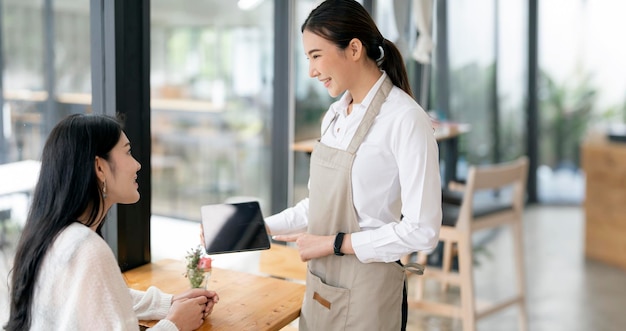 Woman barista talking with customer about coffee drink menu with happy emotion at cafecoffee shop business owner conceptService mind waiter